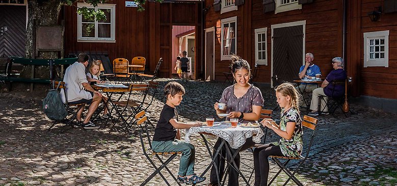 Människor som fikar i en innerträdgård