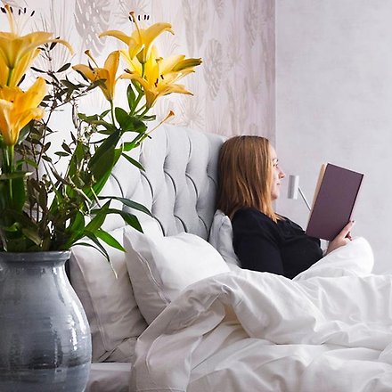 Kvinna läser i hotellsäng